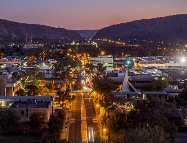 Panoramic view of the Alice Springs township illuminated at dusk, looking toward Heavitree Gap from Anzac Hill Lookout.