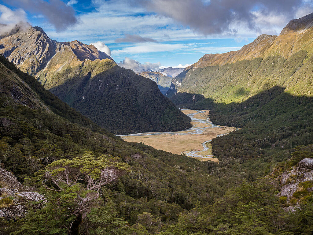 High-altitude alpine landscape on Day 2 of the Routeburn Track, showing the winding river basin, rocky terrain, and dramatic clouds over the Southern Alps.