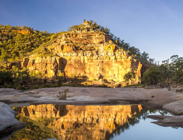 The Pyramid rock formation reflecting in a quiet creek pool at Porcupine Gorge National Park